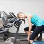 Woman sleeping on bike workout machine